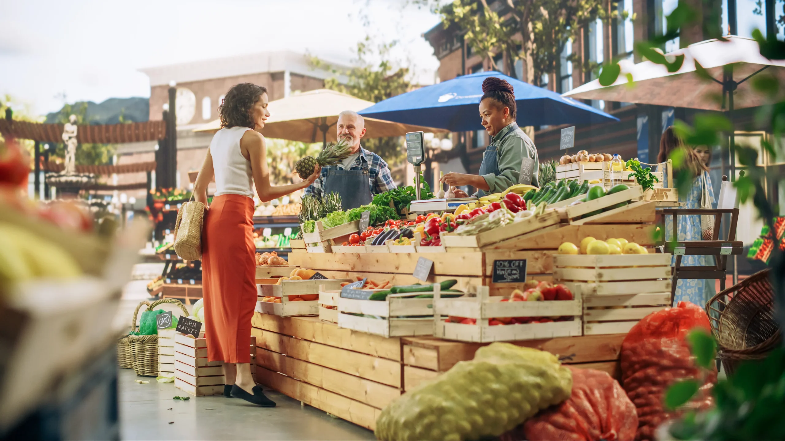 Mujer comprando verduras a productores