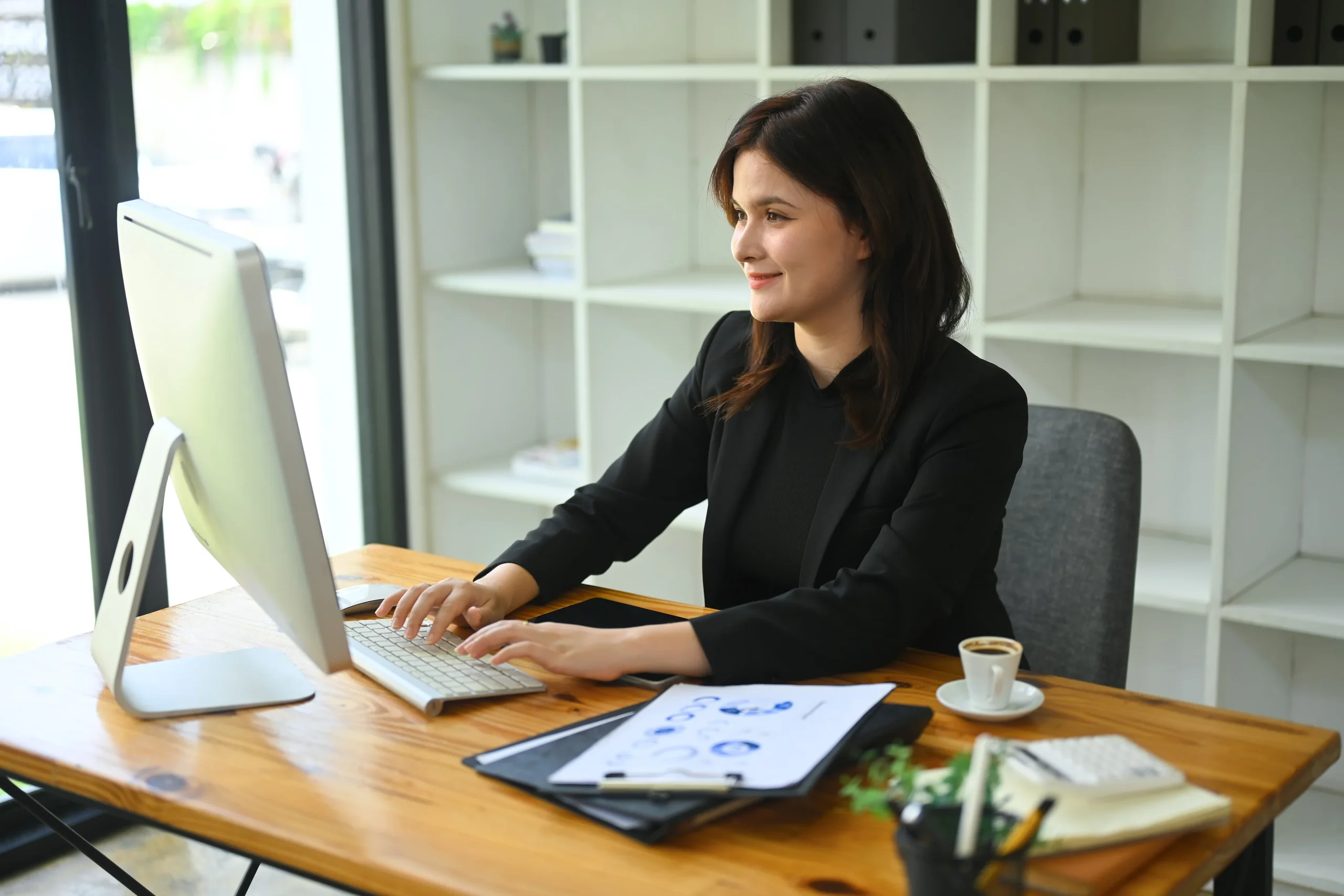 Mujer en un escritorio trabajando en su computadora