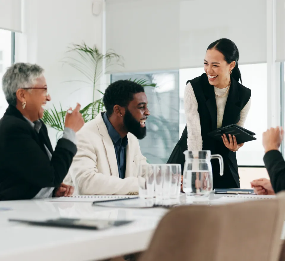 Grupo de personas diverso sonriendo en una sala de reuniones