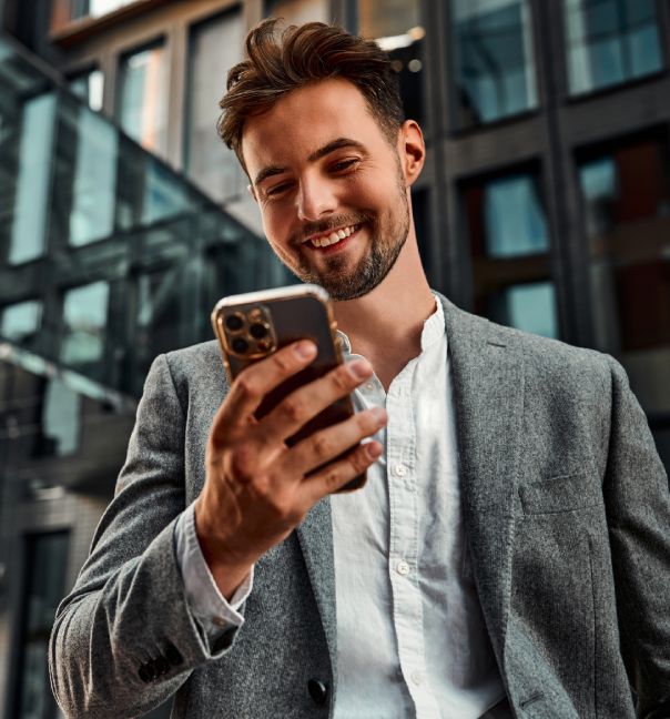 imagen de un hombre sonriendo con un celular en la mano