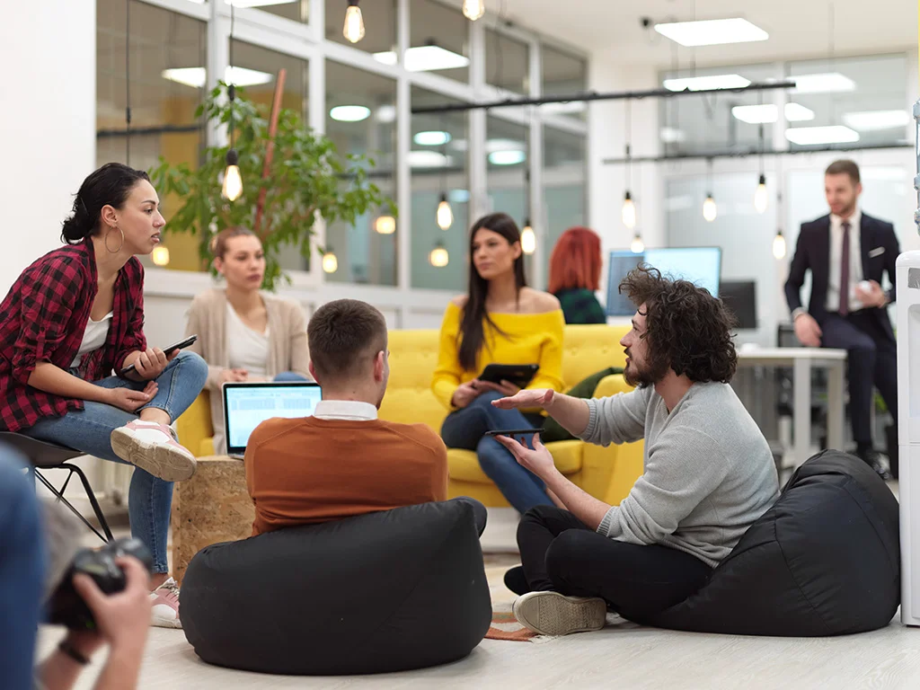 Grupo de personas reunidas y en el centro una laptop