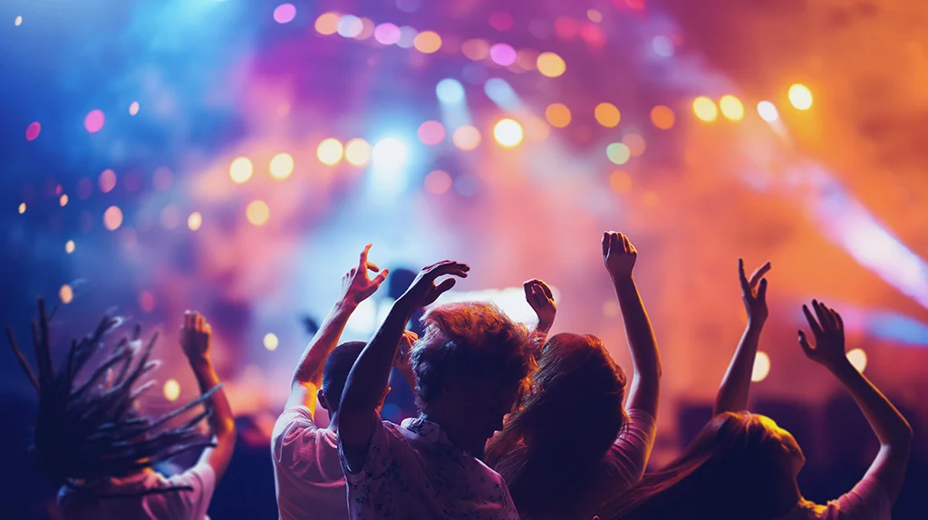 Multitud de personas en un concierto levantando las manos, disfrutando de la música y la atmósfera vibrante del evento